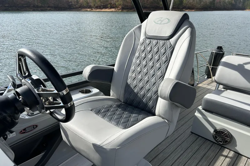 Slide: The Image of Captain's chair on 2021 Harris Solstice 250 boat, featuring quilted upholstery and sleek steering wheel. - 14