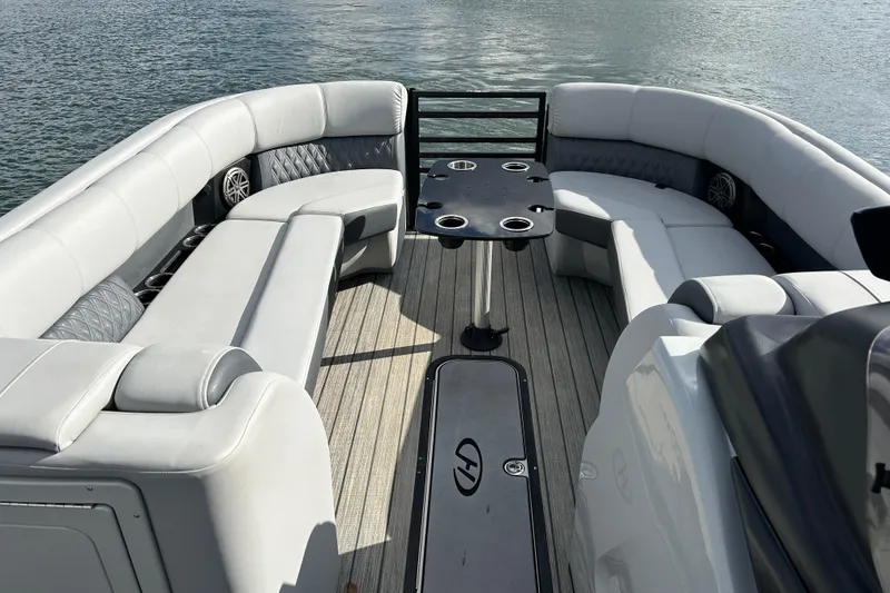 Slide: The Image of 2021 Harris Solstice 250 boat interior with luxurious seating and table on water. - 15