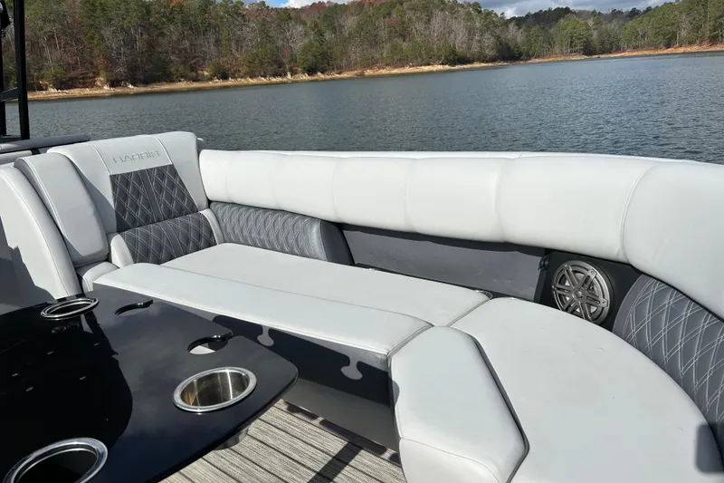 Slide: The Image of Luxurious seating on 2021 Harris Solstice 250 pontoon boat by a scenic lake. - 16