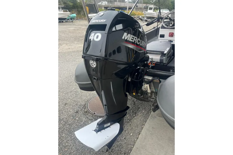 Slide: The Image of 2021 Whaly 435 R with Mercury 40 outboard motor, parked on a gravel surface. - 12
