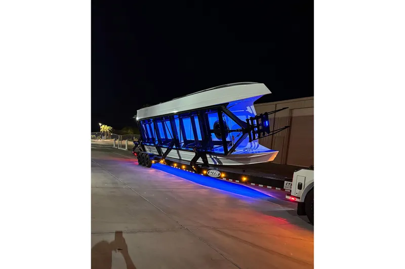 Slide: The Image of 2024 MTI 440X boat on trailer with blue lights at night. - 10