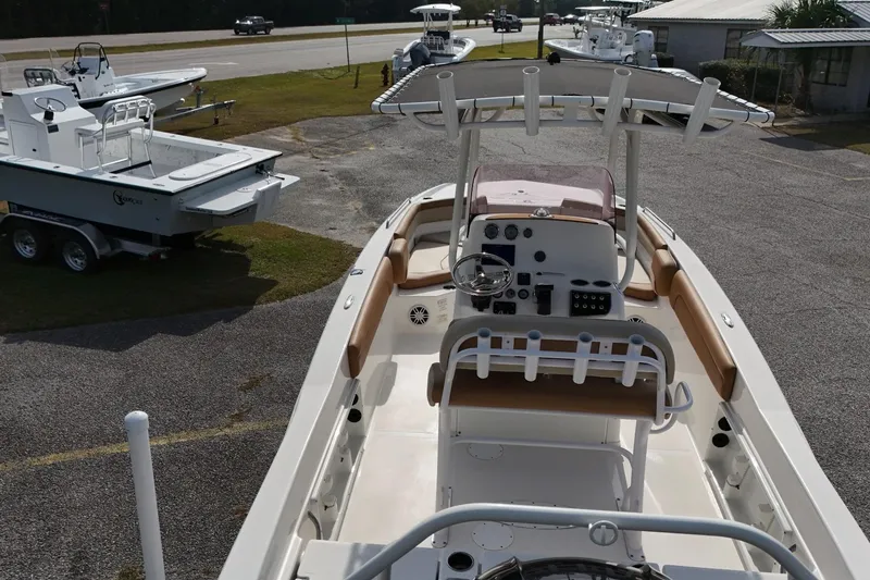 Slide: The Image of 2023 NauticStar 231 Hybrid boat with center console and seating, parked outdoors. - 15