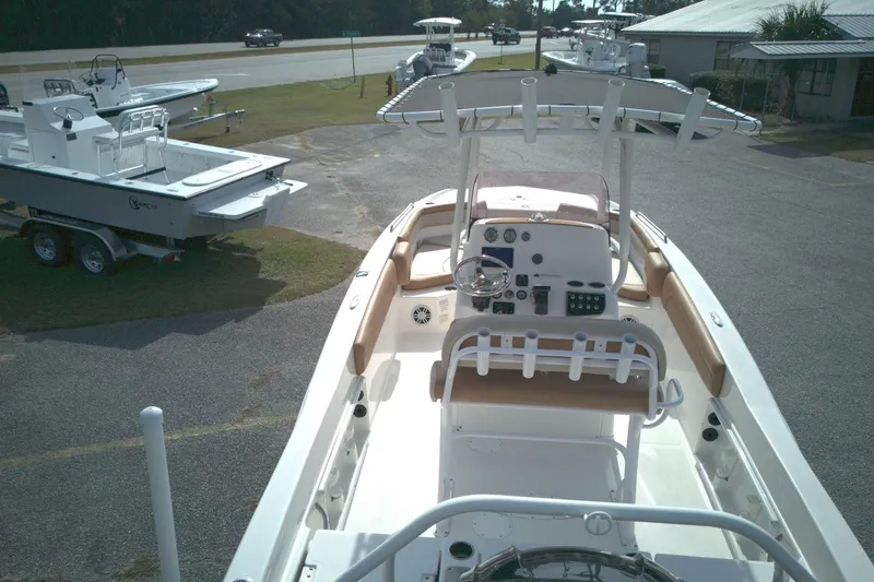 Slide: The Image of 2023 NauticStar 231 Hybrid boat with center console and seating, parked outdoors. - 3