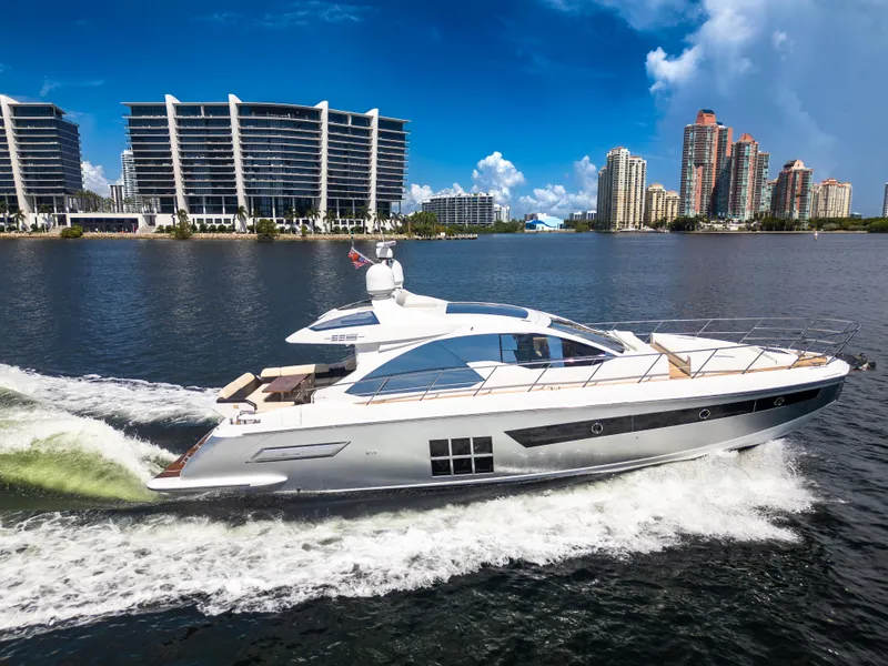 Slide: The Image of 2016 Azimut 55S yacht cruising on water with city skyline in background. - 1