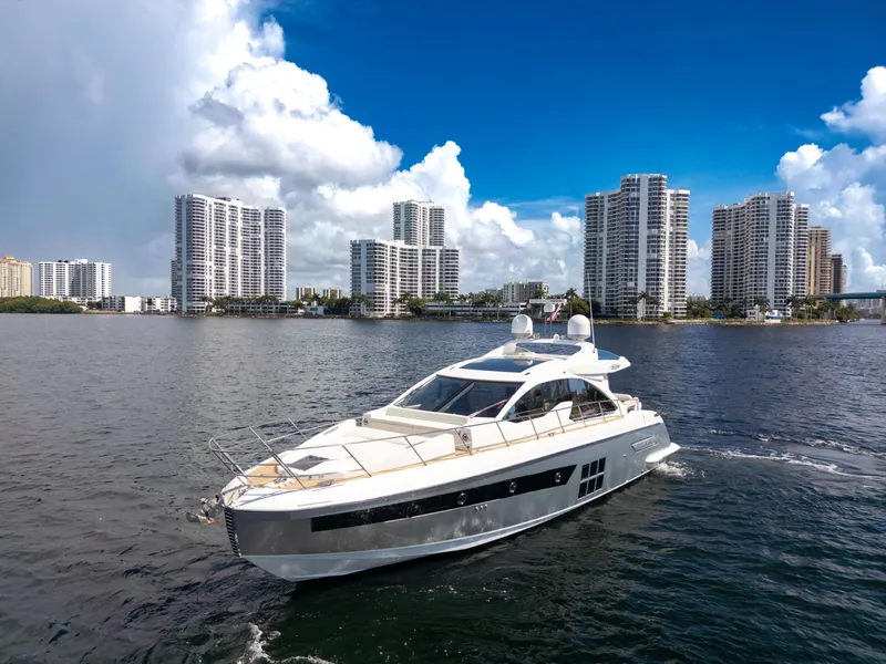 Slide: The Image of 2016 Azimut 55S yacht cruising near city skyline under blue sky. - 11