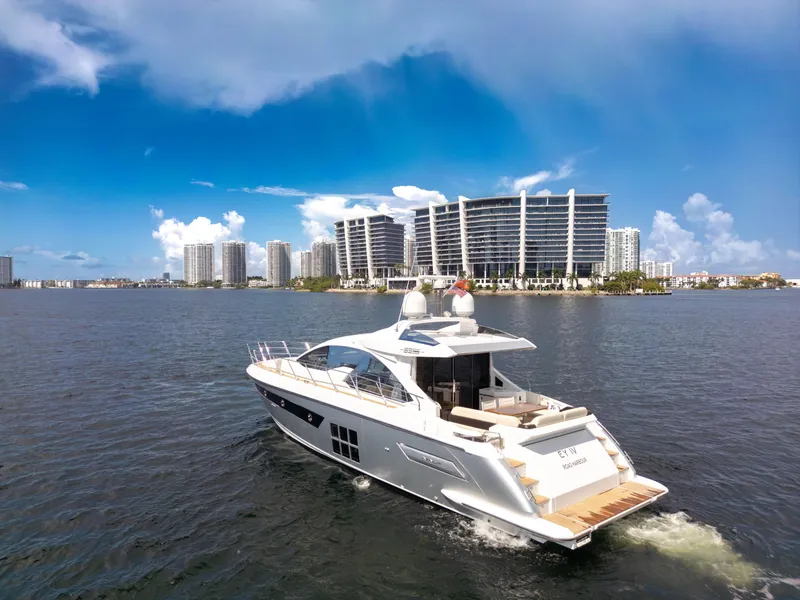 Slide: The Image of 2016 Azimut 55S yacht cruising on a sunny day with city skyline in background. - 13