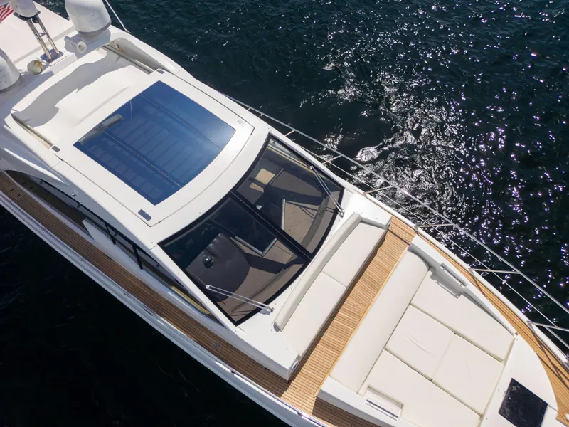 Slide: The Image of 2016 Azimut 55S yacht with sunroof, sleek design, cruising on sparkling water. - 9