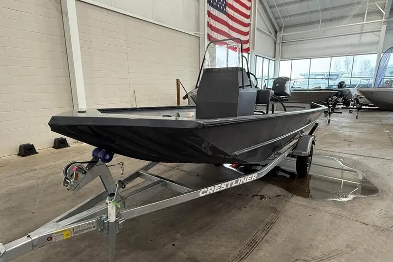 The Image of 2026 Crestliner 1660 Retriever FCC boat on trailer in showroom with American flag. - 0