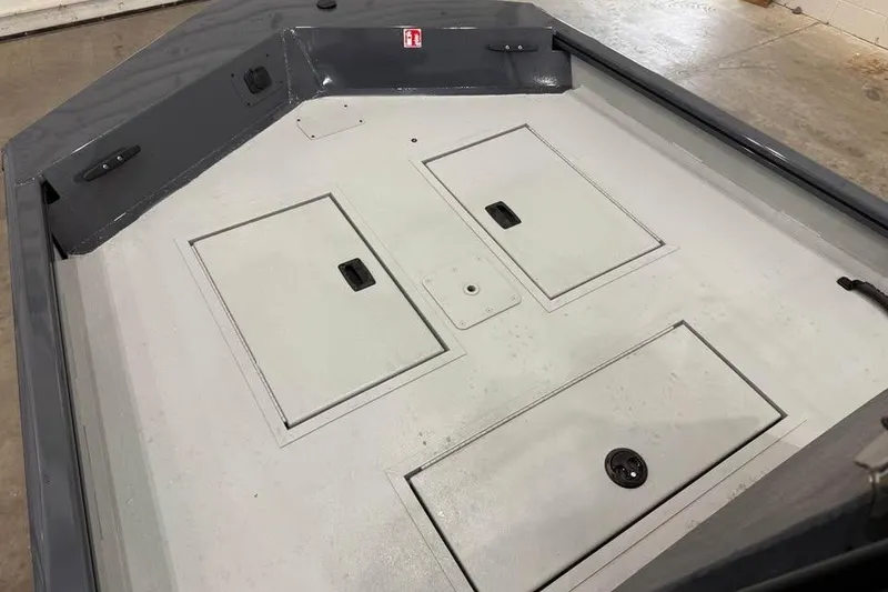 Slide: The Image of 2026 Crestliner 1660 Retriever FCC boat deck with storage compartments. - 10