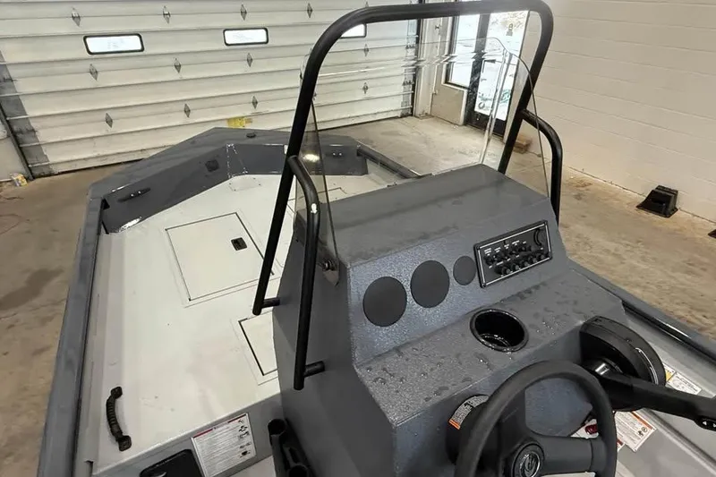 Slide: The Image of 2026 Crestliner 1660 Retriever FCC boat interior with steering console and storage compartments. - 8