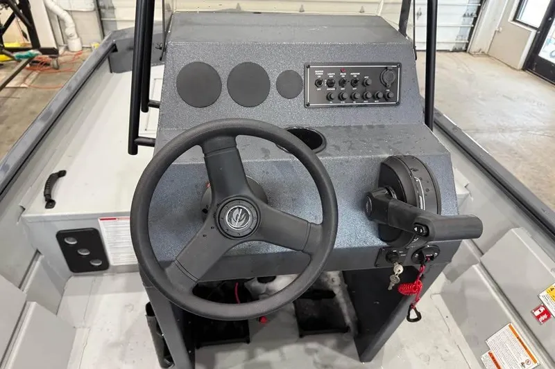 Slide: The Image of Steering console of 2026 Crestliner 1660 Retriever FCC boat, featuring controls and steering wheel. - 9