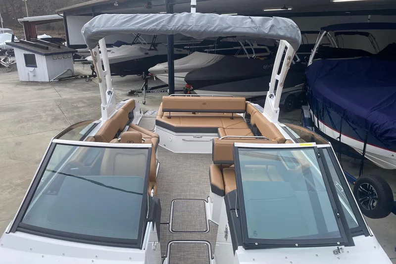 Slide: The Image of 2022 Cobalt R8 boat with tan seating and covered canopy in a showroom. - 12