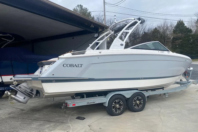 Slide: The Image of 2022 Cobalt R8 boat on trailer, parked in driveway near garage. - 2