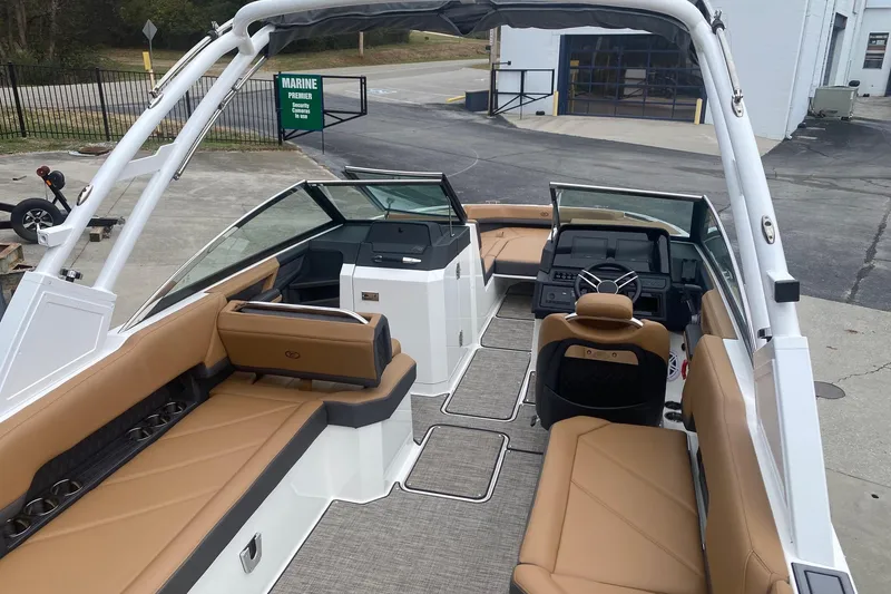 Slide: The Image of 2022 Cobalt R8 boat interior with tan seating and modern dashboard, parked outdoors. - 5