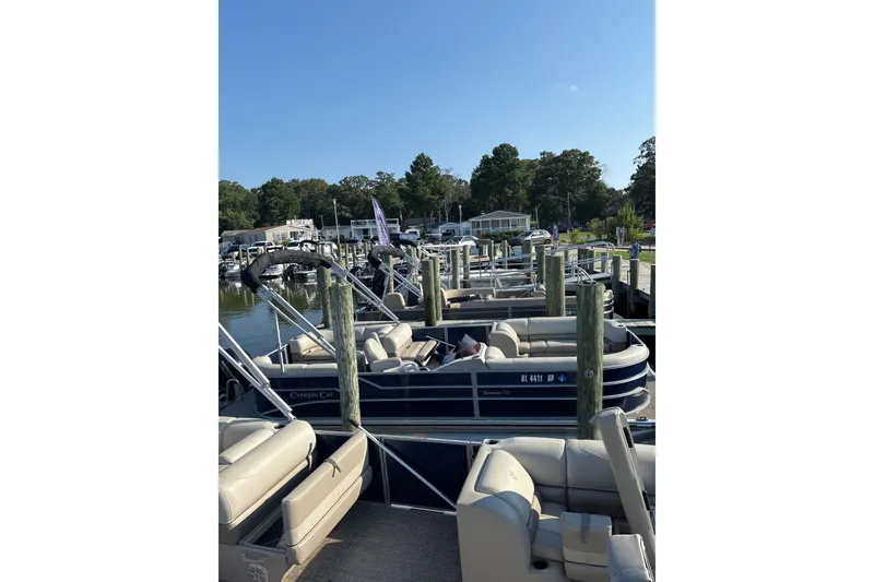 Slide: The Image of 2023 Cypress Cay Seabreeze 232 pontoon boat docked at a marina under clear blue skies. - 5