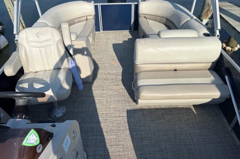 Slide: The Image of 2023 Cypress Cay Seabreeze 232 pontoon boat interior with beige seating and steering console. - 9