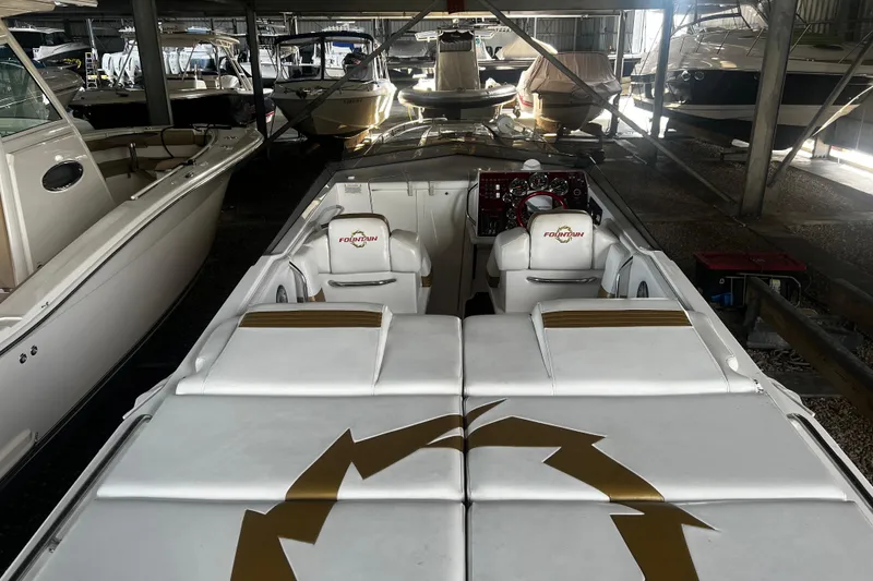 Slide: The Image of 2009 Fountain 42 Executioner speedboat in marina, featuring sleek white and gold interior design. - 15
