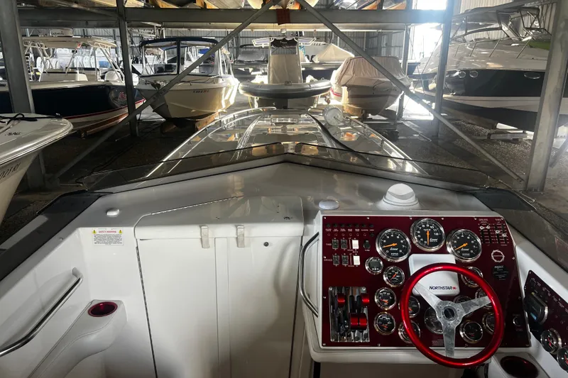 Slide: The Image of 2009 Fountain 42 Executioner boat dashboard in storage, featuring red steering wheel and gauges. - 19
