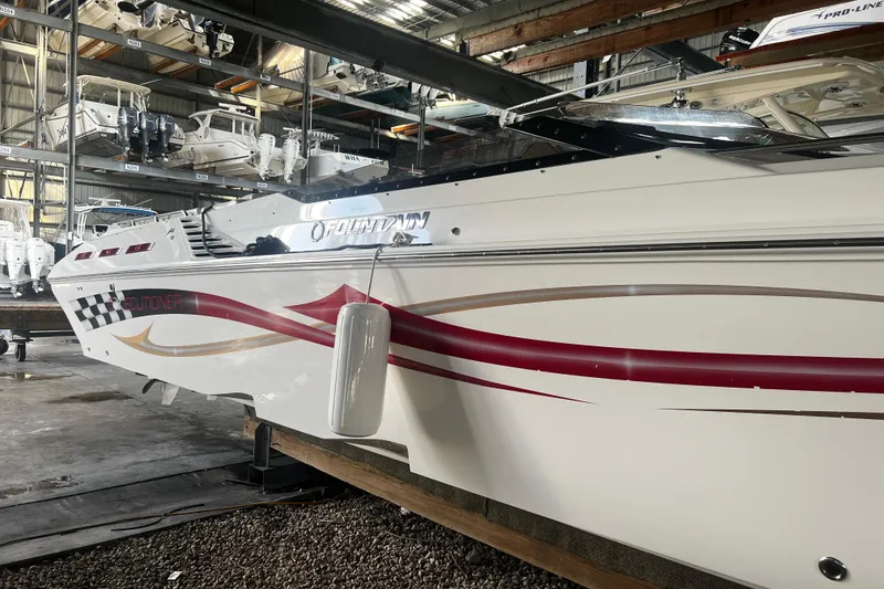 Slide: The Image of 2009 Fountain 42 Executioner boat in storage, featuring sleek design and vibrant graphics. - 2