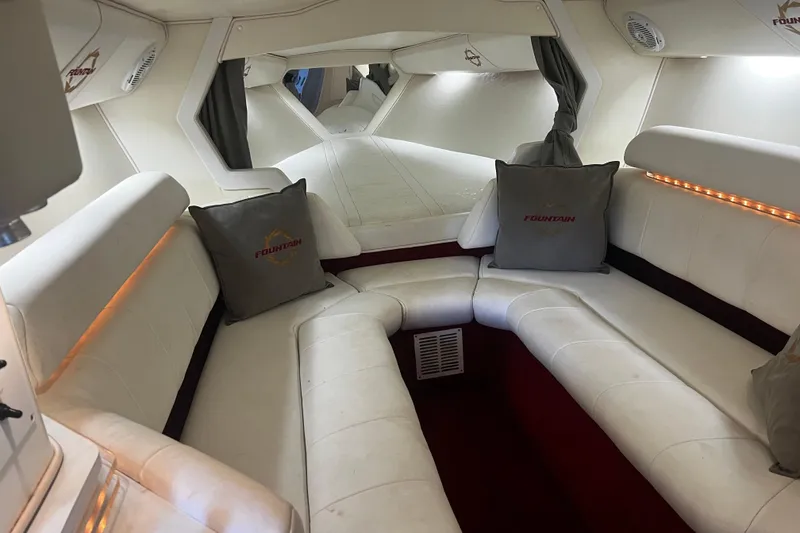 Slide: The Image of Luxurious interior of a 2009 Fountain 42 Executioner boat with white seating and ambient lighting. - 44