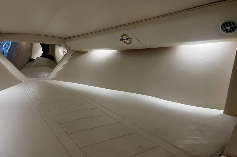 Slide: The Image of Interior cabin of 2009 Fountain 42 Executioner boat, featuring sleek white design and ambient lighting. - 48