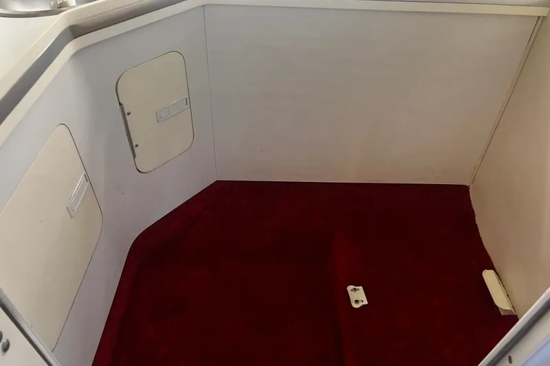 Slide: The Image of Interior of 2009 Fountain 42 Executioner boat with red carpet and storage compartments. - 55