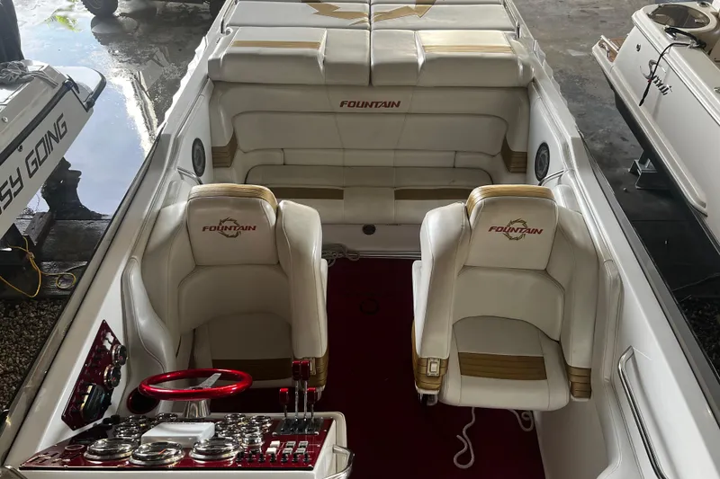 Slide: The Image of 2009 Fountain 42 Executioner boat interior with white seating and red steering wheel. - 59
