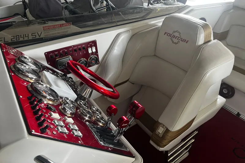 Slide: The Image of 2009 Fountain 42 Executioner boat cockpit with red steering wheel and control panel. - 60