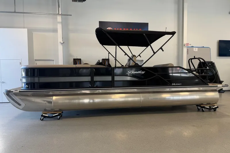 The Image of 2026 Bentley Pontoons Legacy 243 Swingback in showroom, sleek design with black canopy. - 0