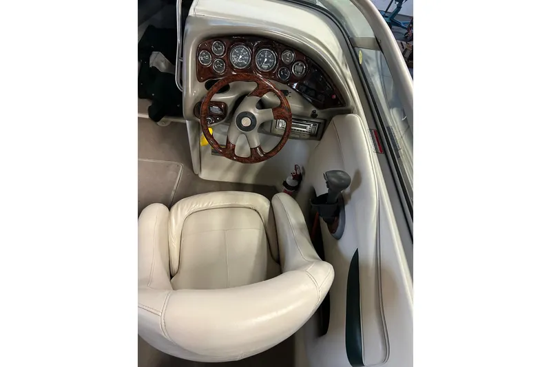 Slide: The Image of 2002 Crownline 230 BR boat interior with steering wheel and dashboard controls. - 10