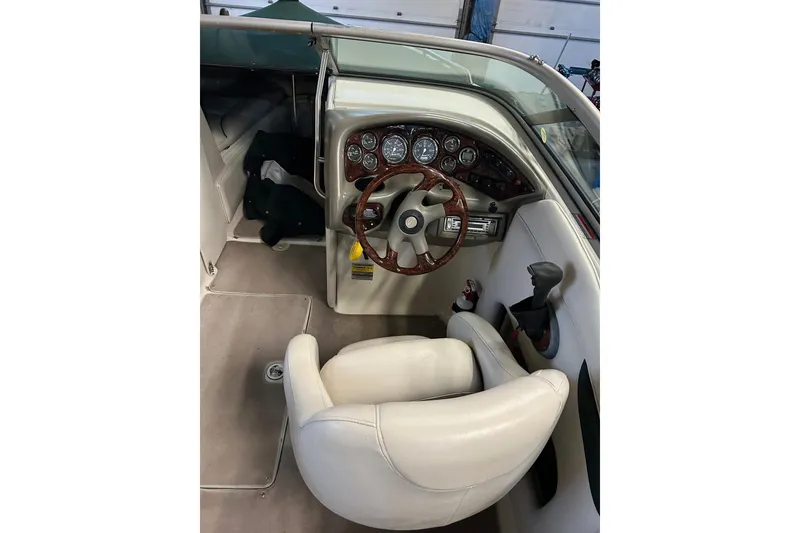 Slide: The Image of 2002 Crownline 230 BR boat interior with steering wheel and dashboard controls. - 11