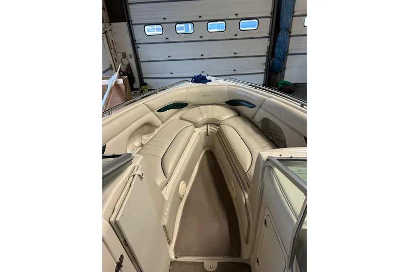 Slide: The Image of 2002 Crownline 230 BR boat interior with beige seating and storage compartments. - 13