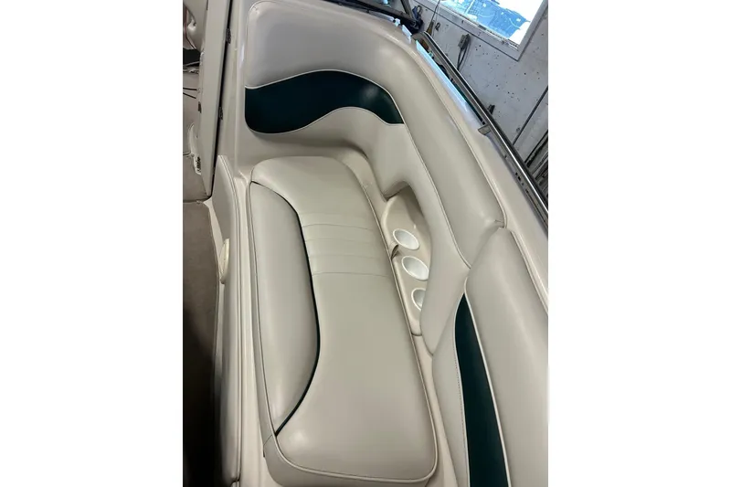 Slide: The Image of 2002 Crownline 230 BR boat interior with white and teal seating, featuring cup holders. - 15