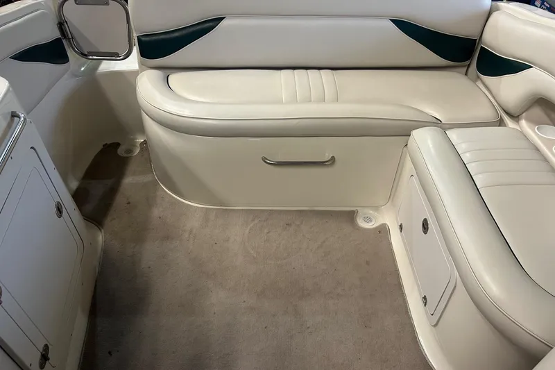 Slide: The Image of 2002 Crownline 230 BR boat interior with white leather seating and carpeted floor. - 20