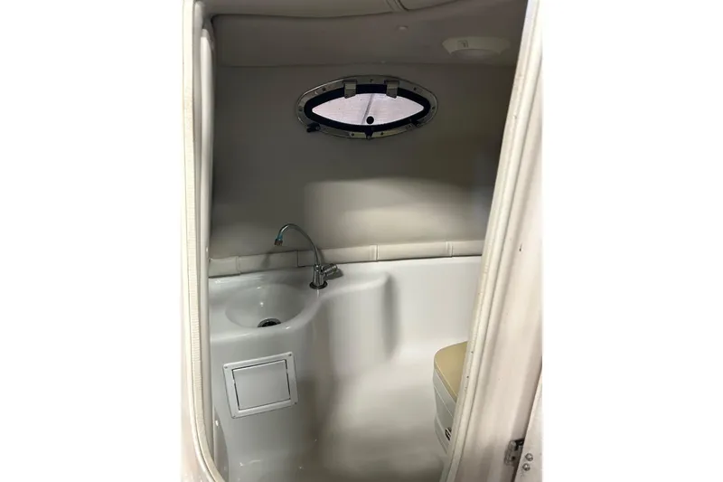 Slide: The Image of 2002 Crownline 230 BR boat bathroom with sink and porthole window. - 24