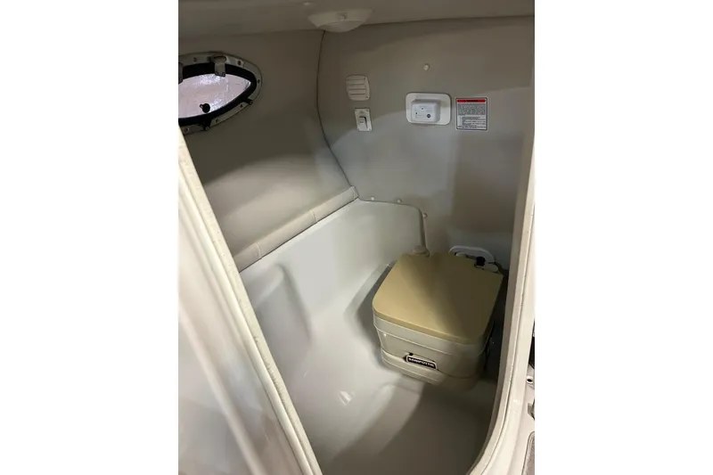 Slide: The Image of 2002 Crownline 230 BR boat interior with compact marine toilet. - 26
