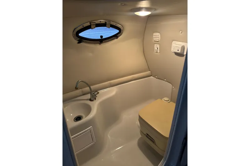 Slide: The Image of 2002 Crownline 230 BR boat interior with sink and portable toilet. - 27