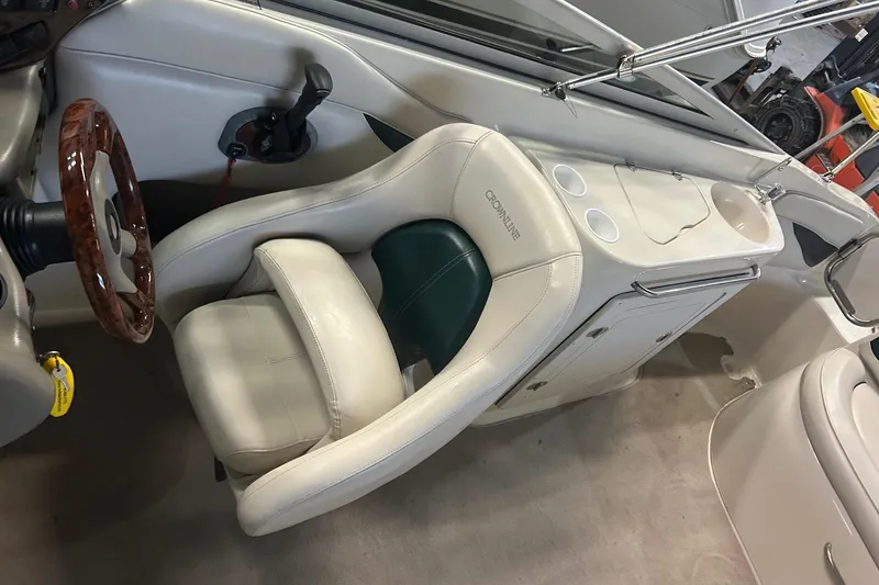 Slide: The Image of Interior of a 2002 Crownline 230 BR boat with leather seating and wooden steering wheel. - 28