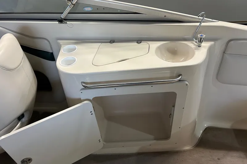 Slide: The Image of 2002 Crownline 230 BR boat interior with sink, storage, and cup holders. - 41
