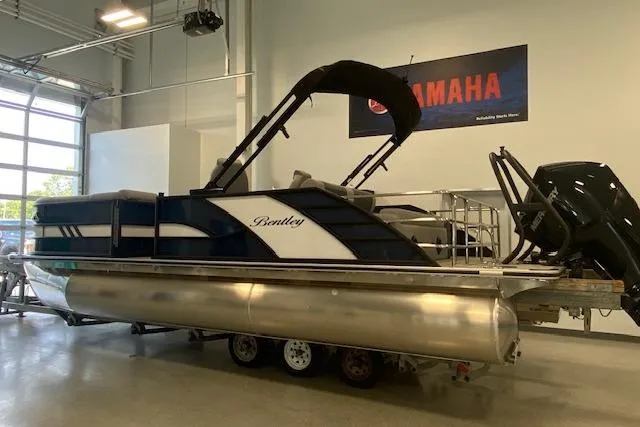 The Image of 2026 Bentley Pontoons Elite 223 Swingback in showroom, featuring sleek design and Yamaha branding. - 0