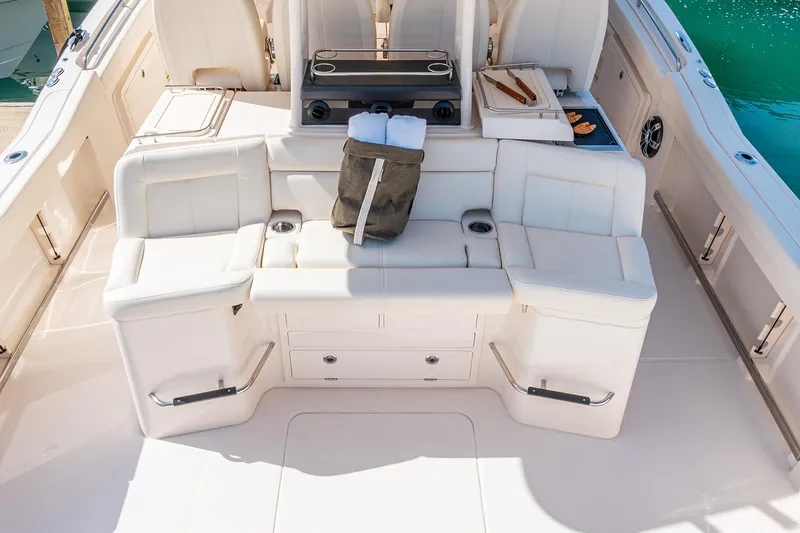 Slide: The Image of Luxurious 2022 Grady-White Canyon 456 boat interior with plush seating and multiple outboard engines. - 12