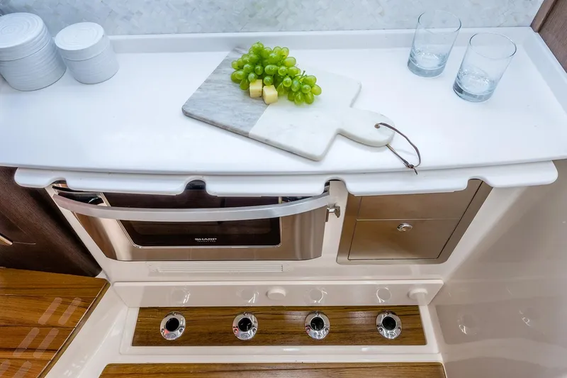 Slide: The Image of 2022 Grady-White Canyon 456 boat with open storage compartment, docked by water. - 16