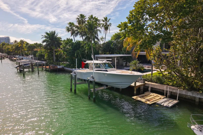 Slide: The Image of Luxurious 2022 Grady-White Canyon 456 boat interior with plush seating, docked by waterfront buildings. - 37