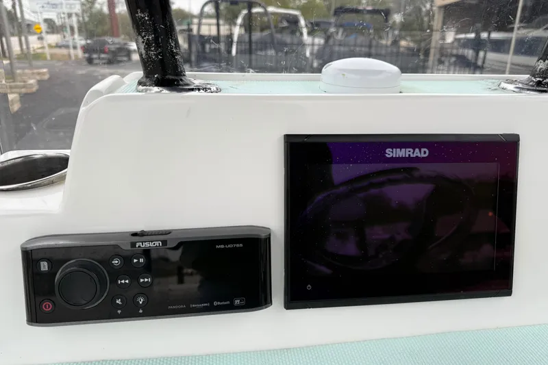 Slide: The Image of 2017 Shallow Sport 24 Sport boat dashboard with Simrad and Fusion controls. - 11