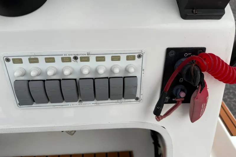 Slide: The Image of Control panel of a 2017 Shallow Sport 24 Sport boat with switches and safety lanyard. - 14