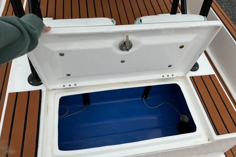Slide: The Image of Open storage compartment on 2017 Shallow Sport 24 Sport boat with teak flooring. - 24