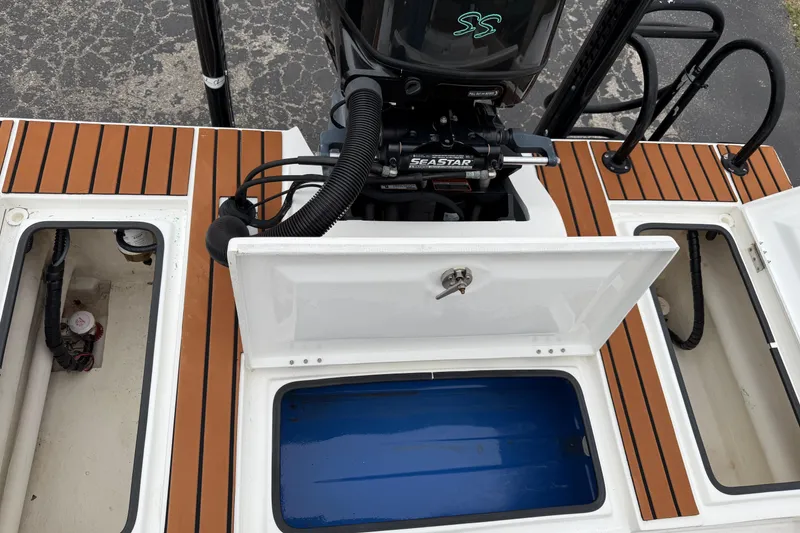 Slide: The Image of 2017 Shallow Sport 24 Sport boat deck with open storage compartments and motor. - 26