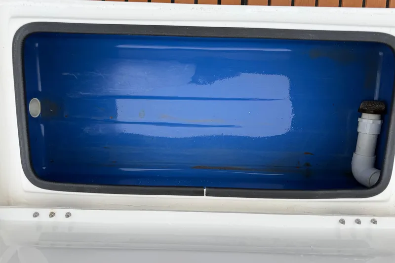 Slide: The Image of 2017 Shallow Sport 24 Sport boat's blue livewell interior with drainage pipe. - 28