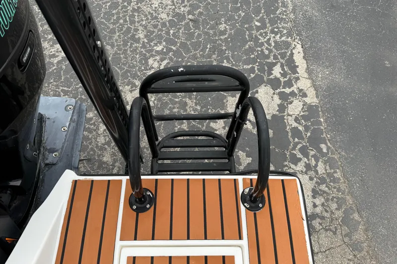 Slide: The Image of 2017 Shallow Sport 24 Sport boat ladder and deck, featuring teak-style flooring. - 29