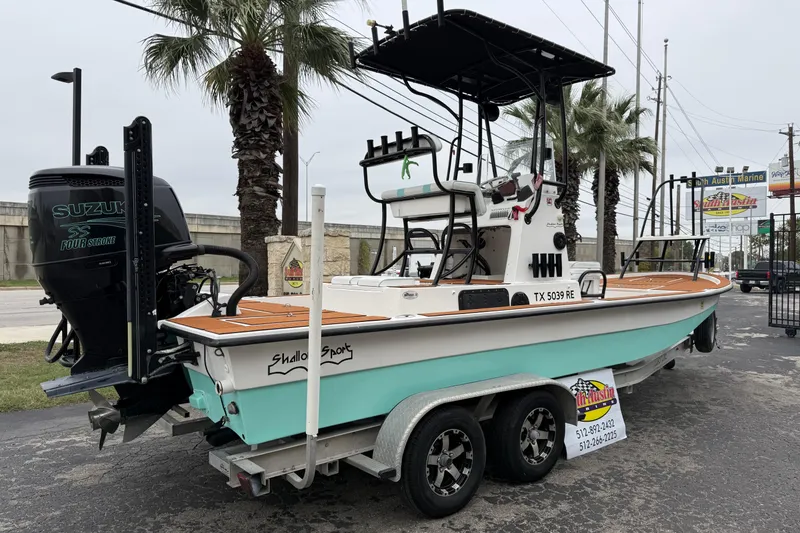 Slide: The Image of 2017 Shallow Sport 24 Sport boat with Suzuki engine on trailer, parked near palm trees. - 35